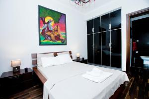 une chambre avec un lit blanc et un tableau au mur dans l'établissement Downtown Apartment, à Thessalonique