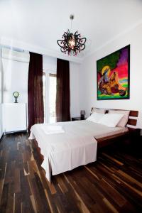 - une chambre avec un grand lit blanc et un lustre dans l'établissement Downtown Apartment, à Thessalonique