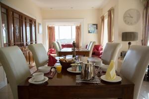 a dining room with a table with chairs and a clock at Bethel Guesthouse in Rosscarbery