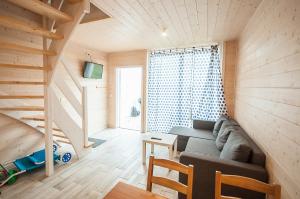 a living room with a couch and a staircase at Wrzosowe Wzgórze in Sarbinowo