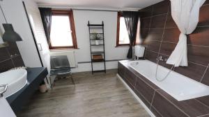 een badkamer met een bad en een wastafel bij Ferienwohnungen Harz Wernigerode in Wernigerode