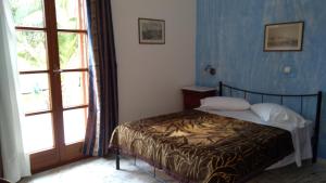 a bedroom with a bed and a large window at Vaporia in Ermoupoli