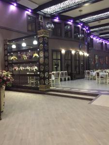 Hotel Shahristan في ديربنت: قاعة احتفالات بها طاولات وكراسي واضاءات ارجوانية