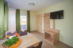 a living room with a table and a flat screen tv at B470Apartments in Gerhardshofen