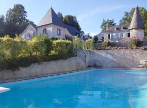 a swimming pool in front of a house at Gîte Le Peyret in Serres-Castet
