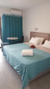 a bedroom with a bed with a blue blanket at Manoli Apartments in Ayia Napa
