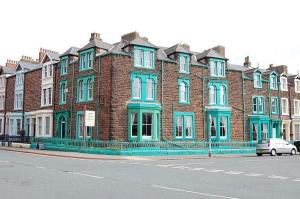 a large brick building with a clock on the side of it at The Waverley Hotel Maryport in Maryport