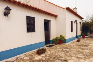 a white and blue building with a door at Casa Rústica in Serra do Bouro