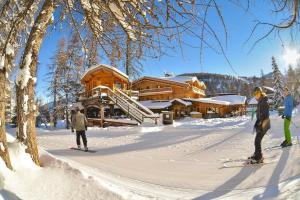 3 persone sugli sci nella neve di fronte a una cabina di Boost Your Immo Vars Le Melezen 36 a Vars