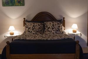 a bedroom with a bed with two lamps on both sides at Casa Rústica in Serra do Bouro