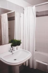 a bathroom with a sink and a white shower curtain at 2º Linea de Playa, Barcelona in La Venteta