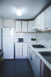 a kitchen with white cabinets and a white refrigerator at 2º Linea de Playa, Barcelona in La Venteta