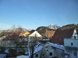 une ville enneigée sur les toits des bâtiments dans l'établissement Lucky Home Ferienwohnung, à Füssen