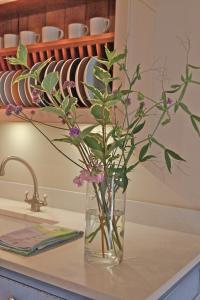 a vase with flowers in it sitting on a counter at Oundle Bespoke Apartments in Oundle