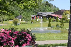 een park met een fontein en bloemen voor een gebouw bij Ferienwohnung Sabrina in Oberstaufen