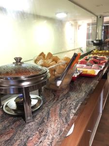 a buffet with bread and other food on a counter at Downtown Santana Hotel in Rio de Janeiro