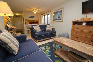 a living room with a blue couch and a table at Admirals View III by KEES Vacations in Kill Devil Hills