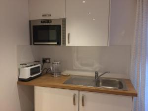 a kitchen with a sink and a microwave at The Citiroom in Chichester