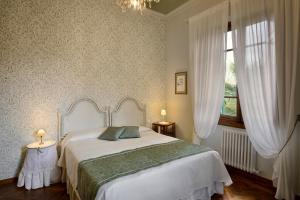 a bedroom with a large white bed and a window at Villa Le Facezie B&B in Terranuova Bracciolini