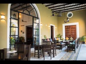 a restaurant with a table and chairs and a couch at Boutique by The Museo in Mérida