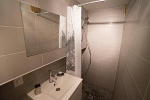 y baño con lavabo y ducha con espejo. en La Petite Salamandre, en Sarlat-la-Canéda