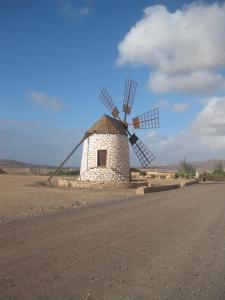 a stone windmill on the side of a road at Casa Mila in Puerto del Rosario