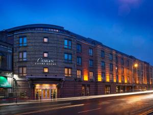 a building on the corner of a street at night at Camden Court Hotel in Dublin