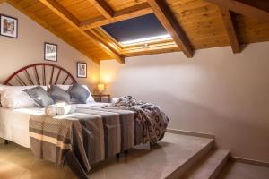 a bedroom with a bed and a wooden ceiling at Amart&igrave;a Apartments in Taormina