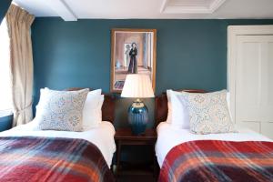 two beds in a room with blue walls at Luxury Regency Apartment in Bath City Centre in Bath
