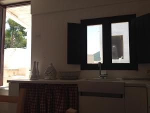 uma cozinha com um lavatório e duas janelas em Masseria S.Oronzo em Monopoli