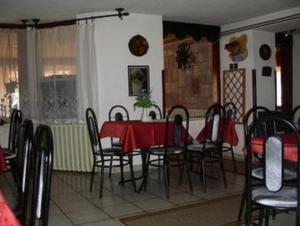 a dining room with a red table and chairs at Lillafüred Kapuja Fogadó in Miskolc