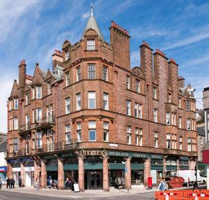 a large brick building on a city street at Argyll Mansions Penthouse in Oban