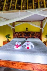 un lit avec deux éléphants au-dessus dans l'établissement Luna Lodge, à Carate