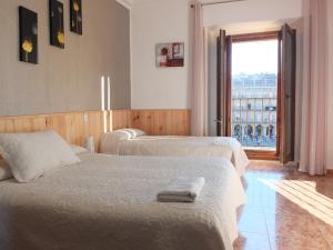 a bedroom with two beds and a window with a view at Los Angeles Plaza in Salamanca