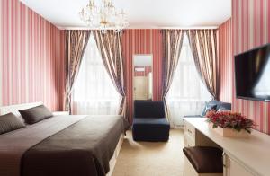 a bedroom with a bed and a tv and curtains at Avenue in Saint Petersburg