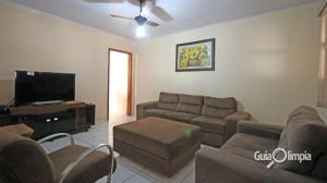 a living room with a couch and a flat screen tv at Casa Temporada Silvana in Olímpia