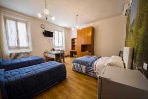 a room with two beds and a couch and a table at Bed & Breakfast Porta Santi in Cesena
