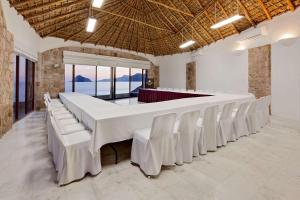 a large dining room with white tables and white chairs at Gaviana Resort in Mazatlán +37 photos