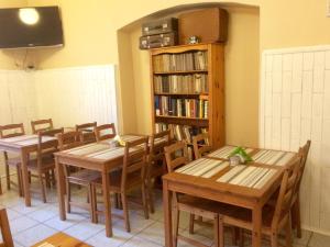 a dining room with two tables and a book shelf at Dom Franciszkański San Antonio in Krakow