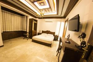 a bedroom with a bed and a flat screen tv at Hotel Mary's House in Selçuk