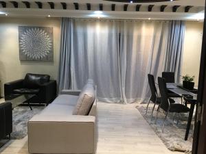 a living room with a couch and a table with chairs at Well located apartment in Casablanca- 12 MO internet- Netflix in Casablanca