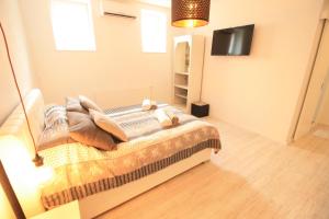 um quarto com uma cama e uma TV em um cômodo em Apartment Marijin Dvor Deluxe em Saraievo
