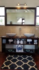 baño con 2 lavabos y espejo grande en Terra Cottage, 1 or 2 bedroom Cottage in Hodges Bay, en Cedar Grove