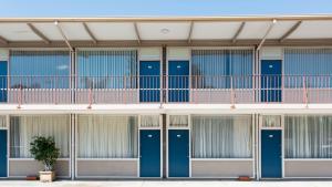 Adelaide的住宿－Bay Motel Hotel，一座带蓝色门和盆栽的建筑