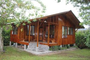 une maison en bois avec des fenêtres en verre dans une forêt dans l'établissement Casitas de Madera, à Mindo