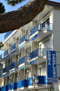 an apartment building with blue balconies and a sign at Residence Costa Templada in Ventimiglia