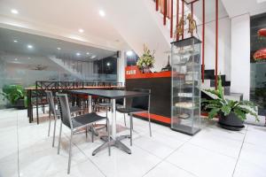 a restaurant with a table and chairs in a room at RedDoorz Plus @ Affandi Gejayan in Yogyakarta