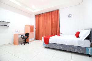 a bedroom with a bed and a desk in it at RedDoorz Plus @ Affandi Gejayan in Yogyakarta