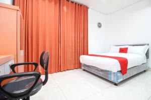 a bedroom with a bed and a chair in it at RedDoorz Plus @ Affandi Gejayan in Yogyakarta