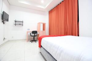 a hotel room with a bed and a desk at RedDoorz Plus @ Affandi Gejayan in Yogyakarta
